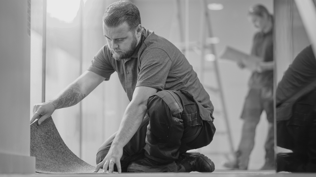 a person putting flooring underlay on the ground